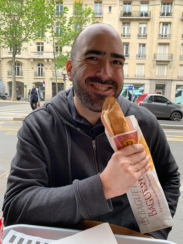 Mark eating a baguette sandwich in Paris